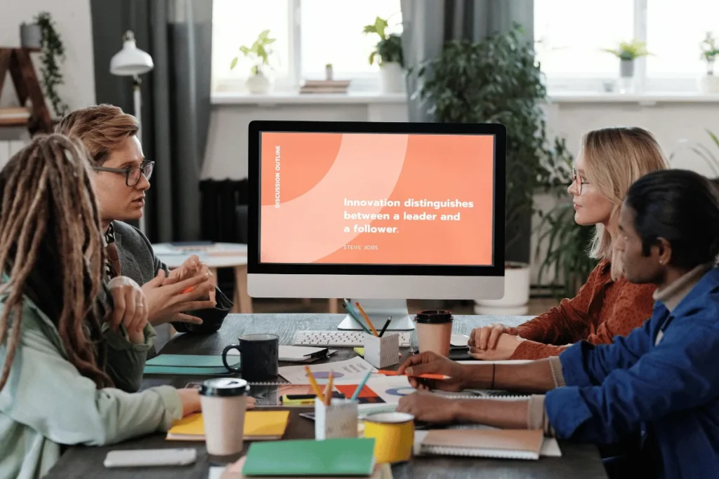 A diverse group of people engage in a meeting around a table.